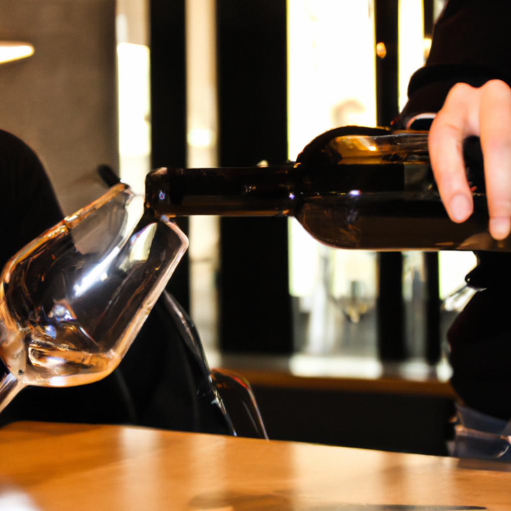 Person pouring wine at bar